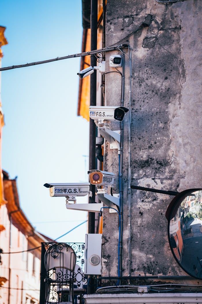 Close-up view of CCTV cameras mounted on a building wall in a city street.